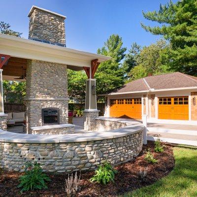 garage and covered patio with stone fireplace 