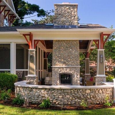 outdoor covered living area with double-sided stone chimney and fireplace
